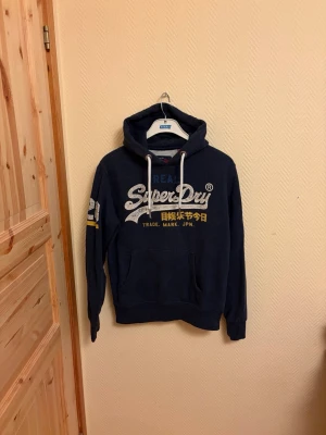The real Superdry Hoodie  - En väldigt snygg The real Superdry Hoodie. I väldigt fint skick skulle säga 9/10 använt ett fåtal gånger | storlek M men passar även storlek L | 🙌.      Hör av er vid mera frågor/bilder 🙌🤝