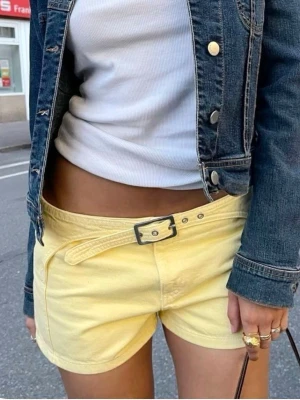 Gula shorts med bälte från MNG - Snygga ljusgula shorts från MNG med tillhörande bälte och hög midja. Gjorda i mjuk bomull, perfekta för varma dagar. Klassisk rak passform och stilren design som ger en fräsch look.