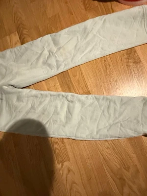 Ljusgråa mjukisbyxor i fleece - Mysiga ljusgrå mjukisbyxor i fleece med rak passform och resår i midjan. Perfekta för chill dagar hemma eller när du vill vara extra bekväm. Klassisk stil utan synliga loggor eller detaljer.