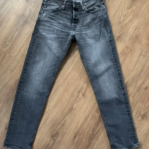 Jack n Jones - Tapered Mike - Snygga svarta jeans från Jack n Jones men schyssta slitningar. Fint skick men tyvärr för små! Storlek: 32/32. Vid fler frågor eller funderingar är det bara att höra av dig 