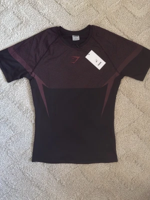 Gymshark Onyx V5 Tröja – Svart & Röd - Gymshark Onyx V5 Tröja – Svart & Röd 👕 Storlek: M 🎨 Färg: Svart med röda detaljer ✨ Skick: Nyskick – endast testad 🧵 Modell: Onyx V5 