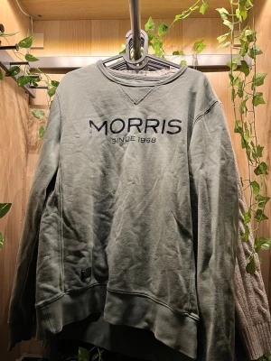 Grön sweatshirt från Morris - Snygg grön sweatshirt från Morris med trycket 'MORRIS SINCE 1968' på bröstet. Tröjan har rund halsringning och ribbade muddar vid ärmslut och nederkant. Perfekt för en avslappnad och stilren look. Pris går att diskuteras vid intresse 🤩😊