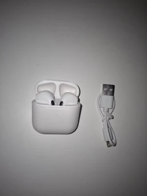 PodsX 4 - Säljer nu dessa snygga och smidiga trådlösa hörlurar i vitt, inspirerade av designen hos AirPods Pro 4. De sitter bekvämt i öronen och ger ett klart och balanserat ljud. Perfekt för musik, samtal och träning.  Kompakt och stilren design  Touchkontroller  Laddningsetui medföljer  Lightning laddare medföljer  Kompatibla med både iPhone och Android  Helt nya och oanvända! Skick: 10/10. Perfekt som budgetvänligt alternativ till AirPods Pro 4.