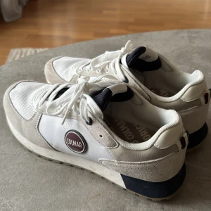 Vita sneakers från Colmar - Snygga vita sneakers från Colmar med grå och mörkblå detaljer. Skorna har en klassisk snörning och en bekväm sula. Perfekta för en stilren look.