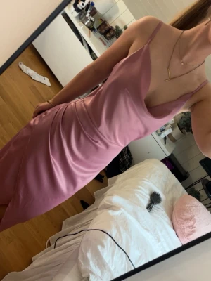 Rosa klänning i satin - Otroligt fin klänning använd bara en gång, sedan dess har den legat i min garderob oanvänd. Köpte den på Zalando av märket Wal G. Vädligt fin och elegent klänning men tyvärr finns det några trådar som dragits både pågrund av dålig produktion och att den förmodligen har fastnat i något som syns på sista bilden men är bara baksidan av klänningen, inget som syns framtill.