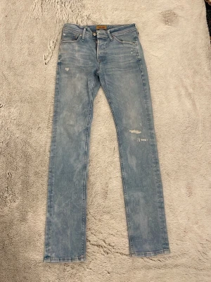 Ljusblå jeans från Jack & Jones! - Säljer ett par ljusblå jeans från Jack and Jones! Helt nya! Storlek 29/32.  Den är slim/glenn. Kontakta vid frågor eller pris. OBS! den är inte sliten, det ska se ut så! 