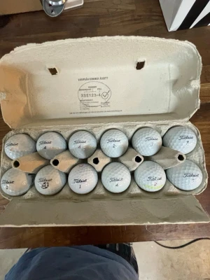 Golfbollar Titleist i äggkartong - Säljer ett gäng vita golfbollar från Titleist, smart förvarade i en äggkartong. Perfekt för dig som vill fylla på golfväskan med extra bollar. Klassisk rund form och slitstarkt material. Flera olika nummer på bollarna. Vissa har repor eller färger på sig men inget som påverkar spelet enligt mig.