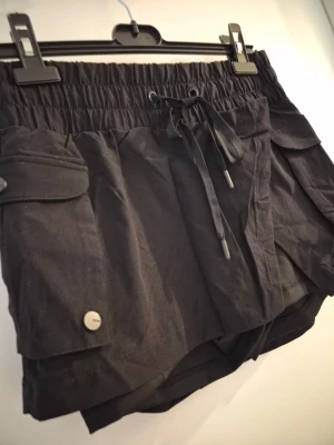Skort från Popflex🌼 - Säljer en skort från Popflex i nyskick~ den har praktiska fickor i det yttre tyget i fickor på shortsen! ^-^ Storleken är XS och säljer dem för dem aldrig kom till användning 
