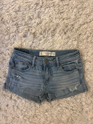 Ljusblå jeansshorts Abercrombie & Fitch - Ljusblå jeansshorts från Abercrombie&fitch. Storlek w25, midjemåttet 32cm rakt över. Skriv för fler bilder. Hör av er vid några funderingar!