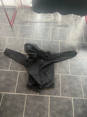 Svart hoodie från sail racing  - Säljer en svart hoodie från sail racing med dragkedja framtill och två fickor. Hoodien har en klassisk huva och är gjord i ett mjukt, stretchigt material som känns sportigt och bekvämt. Perfekt för dig som gillar enkel och stilren design.