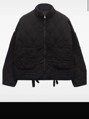 Zara jacket - Säljerw en svart quiltad pufferjacka med hög krage och dragkedja framtill. Jackan har två stora framfickor och justerbar dragsko i nederkant. Perfekt för kalla dagar och ger en trendig oversized look.