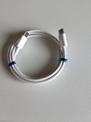 Vit USB-C till USB-C laddkabel 1m - USB-C till USB-C laddkabel, perfekt för att ladda eller synka din mobil eller surfplatta. Kabeln är rund och flexibel med plastmaterial och har kontakter i båda ändar. Passar de flesta moderna enheter med USB-C-port.
