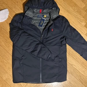 Ralph Lauren jacka - Säljer nu en helt ny Ralph Lauren jacka. Färg Marinblå, Storlek M. Jackan är vattentät, den är gjord av polyester vilket kan vara väldigt skönt och den går att packa ihop till en liten påse vilket kan vara väldigt praktiskt. Nypris 4295kr mitt pris 1499kr. Om du har några funderingar så är det bara att fråga på! ❇️(Lappen sitter inte på längre)