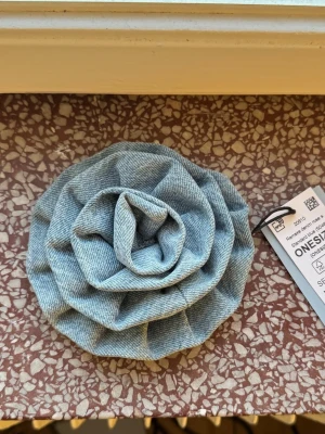 Remade Denim Rose Brosch - Gina Tricot - NY - REMADE DENIM COLLECTION | Gina Tricot. Brosch i denim med form av en blomma. Perfekt för att få in det lilla extra i sin outfit. Går att styla på jacka eller på en byxa ex i hylsan ✨ Helt ny! (Slutsåld) Ord pris : 199,95kr