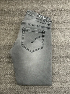 Grå slim fit jeans från Dondup - Snygga grå jeans från Dondup. Modell George. Jeansen har en tvättad look och raka ben. Väldigt bra skick, inga defekter fekter, ÄKTA!