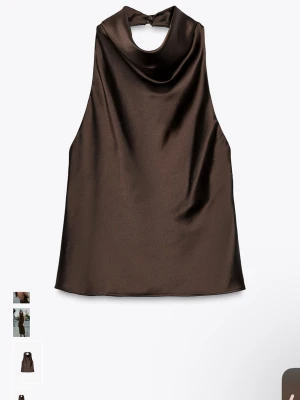 Brun satintopp med hög hals - Snygg brun ärmlös topp i satin med hög, draperad hals och knäppning bak i nacken. Helt oanvänd med prislapp på. 