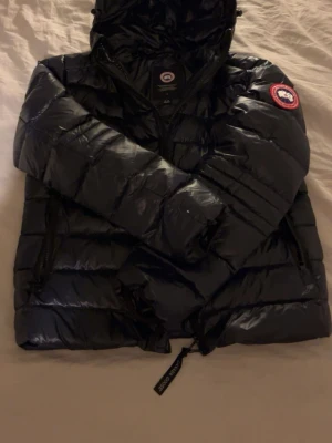 Canada Goose - Mörkblå dunjacka från canada goose som är riktigt snygg och passar till vinter, hösten och våren den är lite kort och skulle säga att den är storlek 164