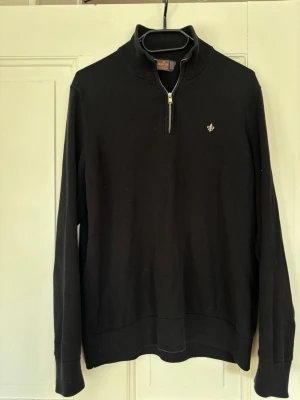 Svart halvzip-tröja från Morris - Säljer min snygga svarta, Morris med halv dragkedja. Tröjan har en Morris-logga broderad på bröstet och ribbade muddar vid ärmslut och nederkant. Är storlek S men skulle kunna passa till M också. Inga defekter finns, hör av er vid frågor!