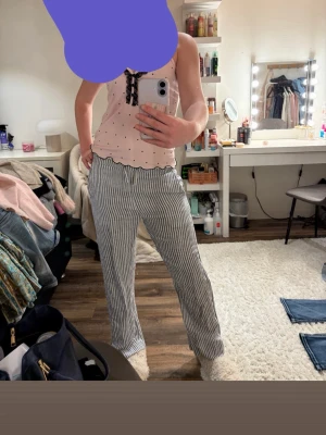 Randiga linnebyxor i blått och vitt - Snygga linnebyxor med blå och vita ränder från Cubus. Byxorna har rak passform, resår i midjan och är tillverkade i ett lätt och luftigt linnematerial. Perfekta för en avslappnad och trendig look.