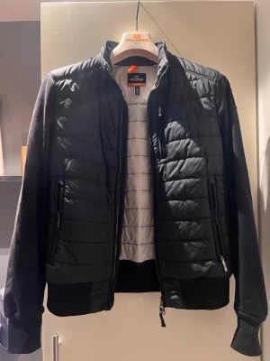 Svart fleecejacka från Parajumpers - Snygg svart fleecejacka från Parajumpers med quiltad front och dragkedja. Jackan har ribbade muddar, hög krage och två fickor med dragkedja. Perfekt för lager på lager och en clean look.