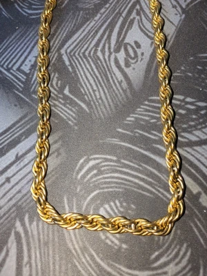 Tjockt guldfärgat halsband och armband  - Säljer ett 10 mm halsband och armband i guldfärg, armbandet är cirka 19 cm långt och halsbandet 60cm. Halsbandet har vanligt lås medans armbandet har ett Diamant lås