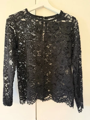 Spets blus - Svart blus med spets från pieces i storlek S. Jättebra skick, använd max 3 gånger!