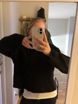 Svart stickad tröja med rund hals - Mysig svart stickad tröja med rund hals och långa ärmar från Gina. 