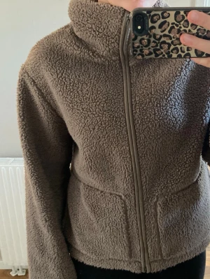 Brun teddyjacka med dragkedja - Mysig brun teddyjacka med hög krage och hel dragkedja framtill.perfekt som vårjacka , aldrig använd
