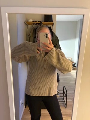 Beige stickad tröja med vida ärmar - Säljer en beige stickad tröja med breda, vida ärmar och halv dragkedja framtill från Hm. Storlek xs/s. Använd en gång
