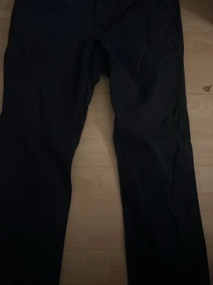 Mörkblåa Chinos från Sebago - Säljer ett par svarta jeans med rak passform. Klassisk femficksmodell och normal midja. Jeansen har en enkel design utan synliga slitningar eller dekorationer. Perfekta för dig som gillar en clean och stilren look.