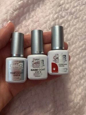 Depend Gel iQ nagellack set - Säljer ett set med Depend Gel iQ nagellack som innehåller Top Coat, Base Coat och färgen Christmas Wishes i rött. Flaskorna är vita med silverfärgade lock och tydliga etiketter. Perfekt för dig som vill göra gellack hemma med UV/LED-lampa.