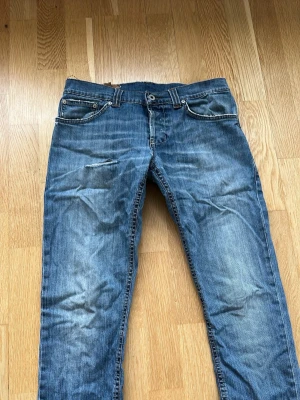 Blå raka jeans med slitningar - Snygga blå jeans med raka ben och slitningar på låret. Klassisk femficksmodell med dragkedja och knapp i midjan. Jeansen har en tvättad look och kontrastsömmar. Perfekt för en avslappnad stil. Osäker på storleken men tror det är 32 dem är klippta så dem är kortare, är 180cm lång och dem passar inte mig i längden.