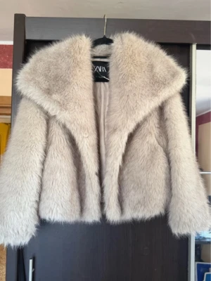 Beige fuskpälsjacka från Zara - Snygg beige fuskpälsjacka från Zara med bred krage och mjukt foder. Använd fåtal gånger och är som ny