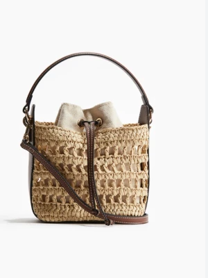 Slutsåld HM väska - Säljer denna Såå fina HM väskan beige med bruna läderdetaljer och axelband. Väskan har en tygpåse inuti med dragsko och en stadig handtag upptill. Endast använd ett fåtal gånger.💕