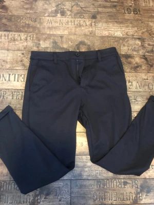 Mörkblå kostymbyxor från SMOG - Tja, säljer just nu ett par väldigt fina kostymbyxor / Chinos från SMOG. Absolut inga defekter på byxorna, passar folk runt 180 cm. Tveka inte att höra av er kring eventuella frågor ✅