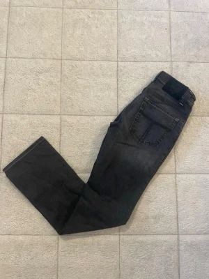 Svarta jeans från tiger of sweden , raka ben - Säljer ett par svarta jeans från tiger of sweden  med slim ben och klassisk femficksdesign. Jeansen har en diskret tvättad look och är tillverkade i ett mjukt denimtyg som sitter snyggt. Perfekta för dig som gillar stilrena och enkla jeans.