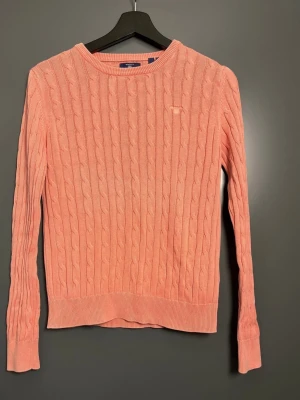 Gant – Rosa – XS – Som Ny - Fin rosa tröja/pullover från Gant i storlek XS. Endast använd en gång, i absolut toppskick  Perfekt som ett stilrent lager ovanför en skjorta, eller som ett mjukt och snyggt plagg till kontoret, möten och vardag med lite extra klass. Kvalitetsplagg från Gant  Skick: Som ny. Använda 1 gång. Färg: Mjuk rosa Storlek: XS 100% bomull