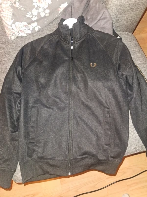 	Fred Perry contrast tape track jkt - Fräsch fred perry zip, helt ny och ej användas mer än att testa då storleken var för liten. Storlek S. Inköps pris 1899 kr men kan tänka mig släppa för 1000!