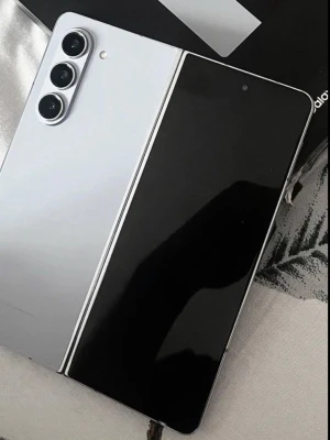 Samsung Galaxy Z Fold 6 vit och svart - Samsung Galaxy Z Fold i snygg vit och svart design. Telefonen har vikbar skärm, tre kameror på baksidan och stilren metallram. Perfekt för dig som vill ha en modern och flexibel Android-mobil.