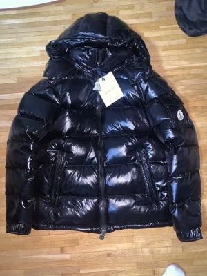  moncler jacka storlek M  - Helt ny moncler jacka, riktigt snygg och varm. Perfekt för vårat kalla väder. Storleken är M alla tags är med och som ni ser förs man direkt till monclers hemsida om man har mobilen vid märket. Fraktar alltid inom 12 timmar, pris är 1699 men vid snabb affär kan jag vara väldigt flexibel. Hör gärna av er😄