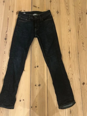 Mörkblå slim jeans från Vailent - Snygga mörkblå slim fit jeans från Vailent med klassisk femficksdesign och smala ben. Jeansen har tydliga kontrastsömmar och är tillverkade i ett stretchigt denimtyg som sitter tajt och bekvämt. Perfekta för en trendig och avslappnad look.