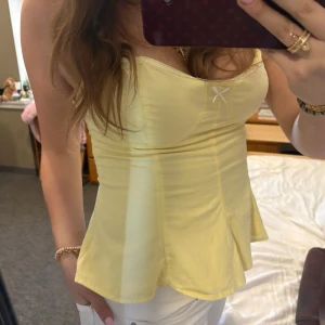 Gul axelbandslös topp med rosett - Söt gul axelbandslös topp med liten rosett framtill och figurnära passform. Så söt från Zara perfekt till sommaren 