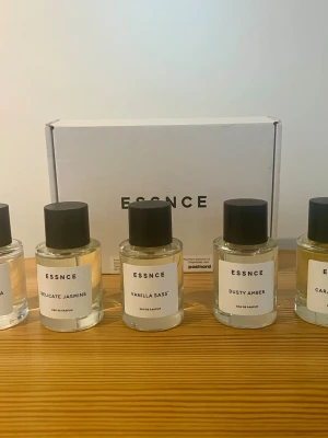 ESSNCE parfymset Eau de Parfum - Upptäck ett parfymset från ESSNCE med fem Eau de Parfum: Delicate Jasmine, Vanilla Sass, Dusty Amber, Carla och Jardin de Flora. Flaskorna är genomskinliga med svart lock och minimalistisk vit etikett. Doftnoter inkluderar jasmin, vanilj, amber, blommor och fruktiga inslag.