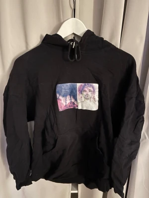 Svart hoodie med tryck framtill - Svart hoodie med ett tryck på bröstet från SHEIN i storlek M kan strykas till leverans om önskas