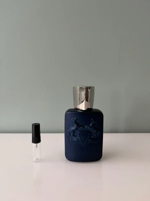 1 ml sample/doftprov av Parfums de Marly Layton - Ett sample på 1 ml av Parfums de Marly Layton. Det är en kryddig vinterparfym av Parfums de Marly. Den börjar starkt och kryddigt, efter ett tag blir den mer söt med vanilj. Våra samples är helt nya och är gjorda av glas. Det är fritt fram att skriva till oss om ni har frågor.