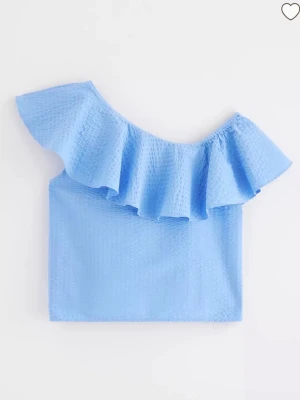 Ljusblå oneshoulder topp med volang - Går ej att få tag i längre!! Supersnygg ljusblå oneshoulder topp med stor volangdetalj längs axeln. Toppen är ärmlös och har en lätt strukturerad yta som ger extra känsla. Perfekt för dig som vill sticka ut med en trendig och fräsch look.