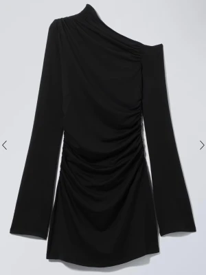 Svart klänning - Klänning från weekday. Helt ny med tag kvar. Glömt lämna tillbaks. Om ni vill ha mer bilder kan jag skicka det. Den är skitsnygg! Långa breda armar och one shoulder. Kort och är insydd på sidorna så man får figur. Jag säljer den för jag glömde lämna tillbaka den och nu är den för stor för mig då jag gått ner lite. 