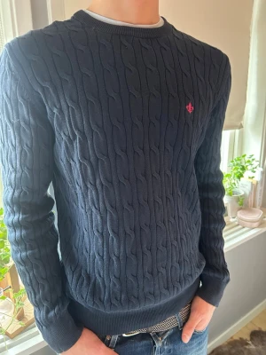 Mörkblå kabelstickad tröja Morris - Storlek L. Modellen är 188cm 80kg