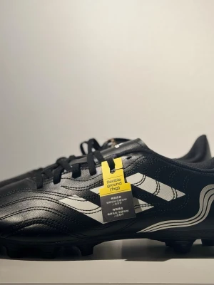 Adidas Copa Sense 4 FXG fotbollsskor – storlek 45, helt nya med etikett - Säljer ett par Adidas Copa Sense 4 FXG i storlek 45. Skorna är helt oanvända, fortfarande med etikett kvar. Perfekt skick, aldrig testade.                                          Sula: FXG (passar gräs/konstgräs/grus)             Originaletikett sitter kvar. 