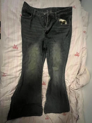 Mörkblå bootcut jeans med slitningar - Säljer ett par mörkblå bootcut jeans med snygga slitningar på låren och lätt utsvängda ben. Jeansen har klassisk femficksdesign och dragkedja. Passar både S pch M. 